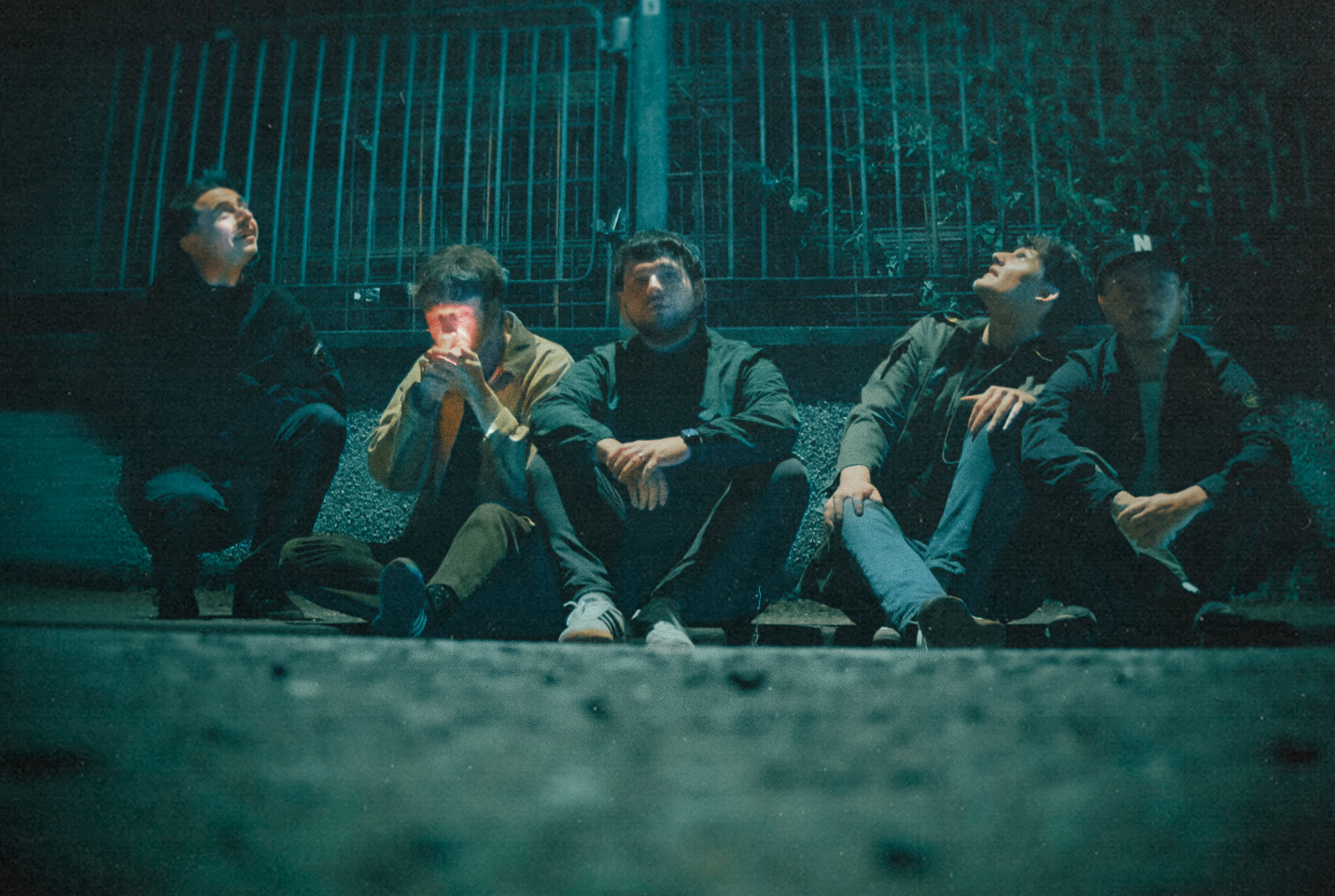 Members of the band 'Vida' sitting on a kerb